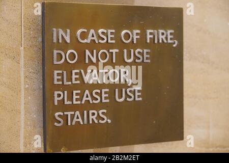 Ein Schild, das im Brandfall Sagt, Nicht Elevator benutzen. Bitte Benutzen Sie Eine Treppe, die die Leute von dem leitet, was sie im Brandfall tun sollten. Stockfoto