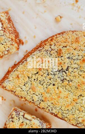 Süßer Sandtart mit Aprikosenmarmelade. In Stücke schneiden, auf einem Brett liegend mit einem Wasserkocher im Hintergrund. Teekanne mit Teetassen und süßem Kuchen Stockfoto