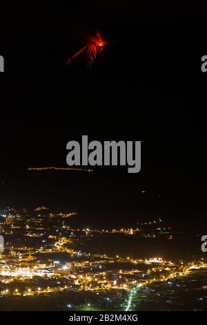 Tungurahua Vulkan Explosion in der Nacht mit der Stadt Patate im Vordergrund. Stockfoto