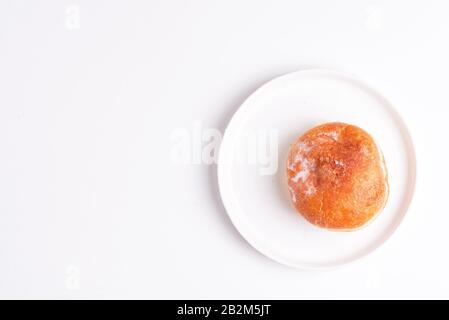 Frisch gebackener hausgemachter Donut-Zucker, der auf einer weißen Keramikplatte auf hellgrauem Hintergrund verglast ist. Draufsicht. Stockfoto