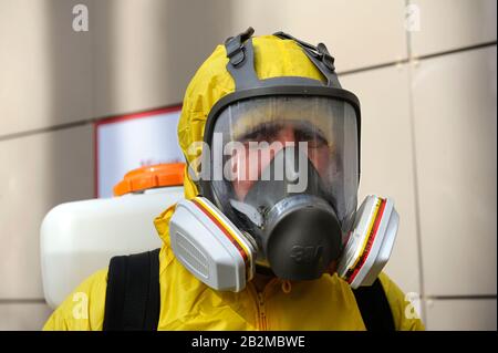 Rettungssanitäter tragen gelbes Schutzkostüm und maskieren das Desinfektionscoronavirus mit dem motorisierten Rucksackzerstäuber. Februar 26.2020. Kiew, Ukraine Stockfoto