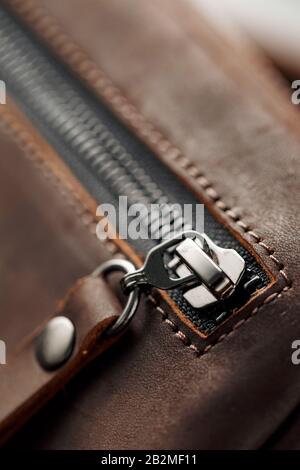 Nahaufnahme aus braunem Echtleder, handgefertigt auf dunklem Hintergrund. Nahaufnahme Stockfoto