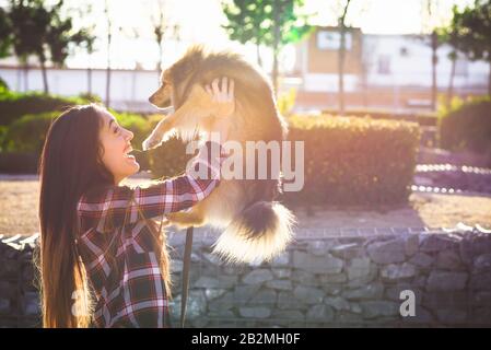 Glückliche Frau, die einen liebenswerten Hund mit Platz für Text hält Stockfoto