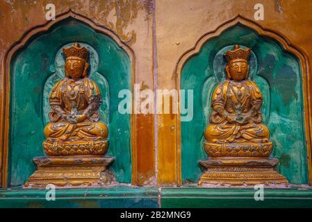 Buddha-Statuen an einer Fassade der Halle des Meeres der Weisheit, die auf Yiheyuan - Sommerpalast, ehemaliger imperialer Garten in Peking, China, errichtet wurde Stockfoto