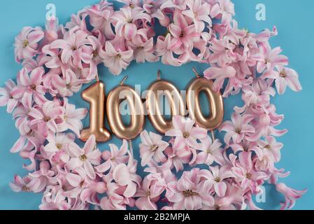 1000 Follower-Karte. Vorlage für soziale Netzwerke, Blogs. Hintergrund mit rosafarbenen Blumenblättern. Banner zur Feier der sozialen Medien. 1K Online-Community-Fan Stockfoto