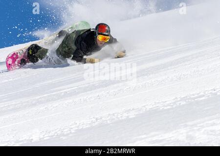 Snowboarder in Aktion auf einer verschneiten Strecke Stockfoto