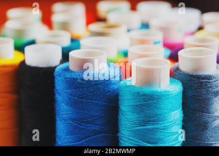 Bunte Spulen von Nähfaden. Farbiges Gewinde zum Nähen. Texturhintergrund Stockfoto