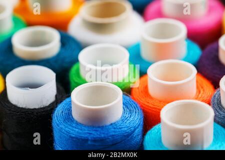 Bunte Spulen von Nähfaden. Farbiges Gewinde zum Nähen. Texturhintergrund Stockfoto