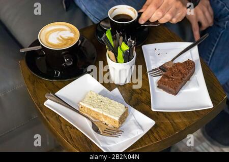 Cappuccino und Espresso-Kaffee auf schwarzen Keramikbechern. Stockfoto