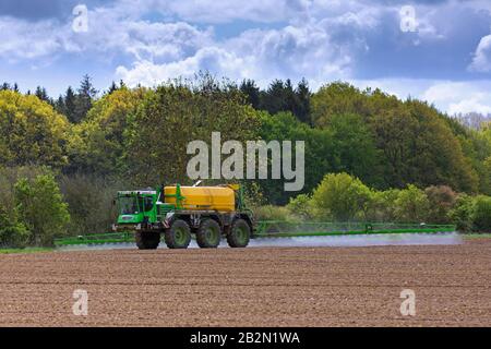 Bauer sprüht im Frühjahr Pestizide/Insektizide/Unkrautmörder/Herbizide über Feld/Ackerland Stockfoto