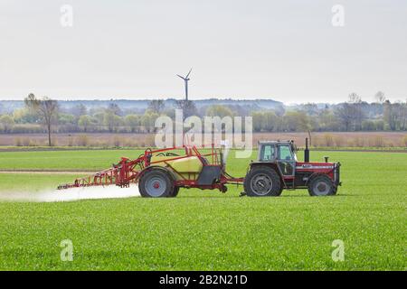 Bauer sprüht im Frühjahr Pestizide/Insektizide/Unkrautmörder/Herbizide über Feld/Ackerland Stockfoto