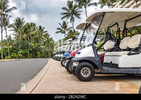 Elektrogolf - in Hamilton Island hintereinander geparkte Personenkraftwagen. Stockfoto