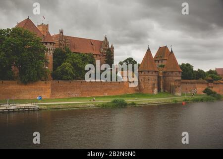 August 2019, Malbork, Polen: Blick auf Mauern und Türme einer Malbork-Burg über einen Noagt-Fluss Stockfoto