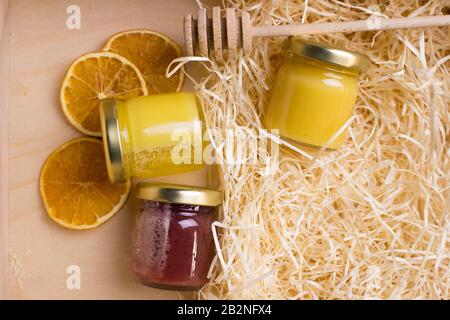 Honig im Glasbecher auf einem Holzboden. Hintergrund mit frischem Honig in klaren Glasgefäßen. Stockfoto