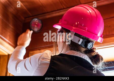 Nahaufnahme des Inneninspektors bei der Luftqualitätskontrolle im Innenbereich, Suche nach Schimmel- oder Pilzproblemen auf dem Holzdach mittels Lupe Stockfoto