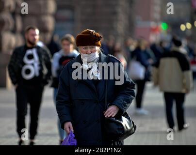 Ältere Frauen in einer Schutzmaske gehen die Straße hinunter, um sie vor der Bedrohung zu schützen.der stellvertretende Gesundheitsminister der Ukraine und der oberste Sanitätsarzt des Landes, Viktor Lyashko, berichteten über den ersten bestätigten Fall eines neuen Coronavirus, Covid-19 in der Ukraine. Nach Angaben des Gesundheitsministeriums wurde am 29. Februar ein Mann in der Stadt Tschernivtsi hospitalisiert, zuvor hatte er Italien während einer Touristenfahrt besucht. Stockfoto