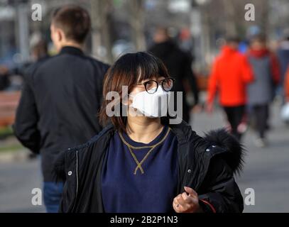 Eine Frau in einer Schutzmaske läuft auf der Straße als Schutzmittel gegen die Bedrohung hinab.der stellvertretende Gesundheitsminister der Ukraine und der Chefarzt des Landes, Viktor Lyashko, berichteten über den ersten bestätigten Fall eines neuen Coronavirus, Covid-19 in der Ukraine. Nach Angaben des Gesundheitsministeriums wurde am 29. Februar ein Mann in der Stadt Tschernivtsi hospitalisiert, zuvor hatte er Italien während einer Touristenfahrt besucht. Stockfoto