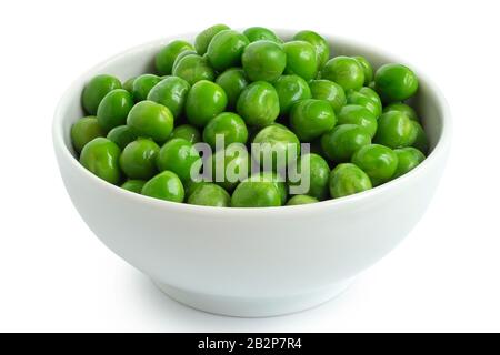 Frische grüne Gartenerbsen in einer weißen, auf Weiß isolierten Keramikschale. Stockfoto