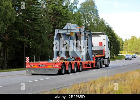 Weißer Volvo FH-Truck transportiert im Sommer Übergröße auf Anhänger entlang des Highway 25. Raasepori, Finnland. Juli 2019. Stockfoto