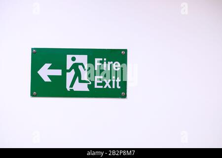 Hinweisschild für den Austritt aus dem Feuer an der weißen Wand, Nahaufnahme Stockfoto