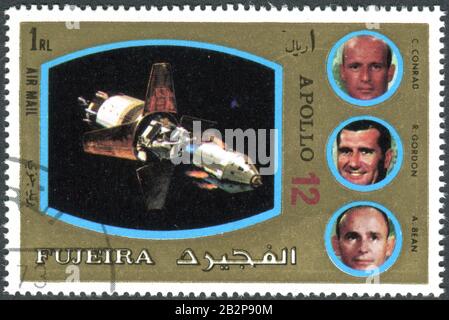 FUJEIRA - CIRCA 1972: Eine in Fujeira gedruckte Briefmarke, die dem Apollo-Programm ausgestellt wurde und die Besatzung von Apollo 12, ca. 1972, abbildet Stockfoto