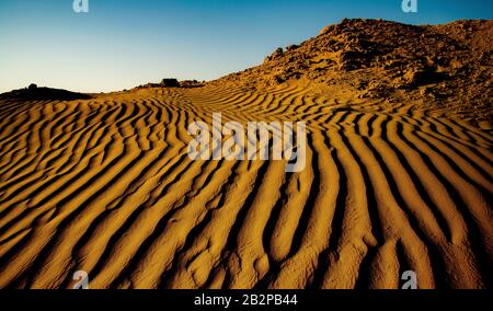 Farbbild in der Dämmerung aufgenommen, abstrakte Ansicht von Wellen Sand Muster durch, die Wüste, Stockfoto