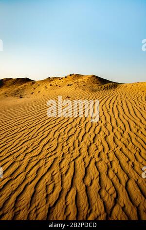 Bild aufgenommen in der Dämmerung, abstrakte Ansicht von Wellen Sand Muster durch die Wüste, Stockfoto