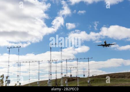 Flugzeug nähert sich Start- und Landebahn an einem teilweise bewölkten Tag. Stockfoto