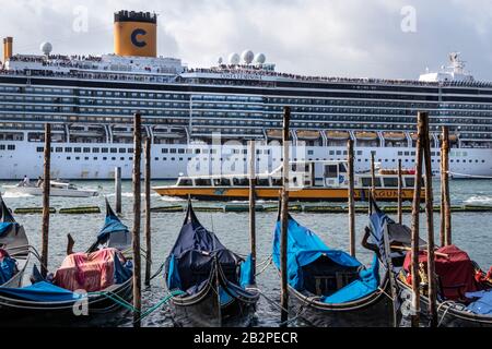 Tägliche Ankunft des Kreuzfahrtschiffs am frühen Morgen auf den Markusplatz, mit Gondeln im Vordergrund, Venedig, Italien Stockfoto