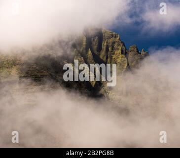 Fliessende Felsen der Na Pali Berge durch die Wolken von Pihea Trail in der Nähe Von Pu'u O Kila Aussichtspunkt auf Kauai Stockfoto