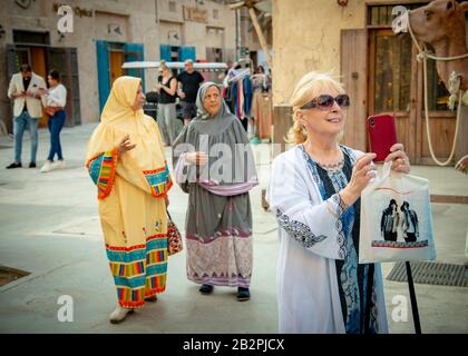 Dame mittleren Alters/Tourist, die Fotos auf dem iphone auf dem Altstadtmarkt in Dubai VAE Stockfoto