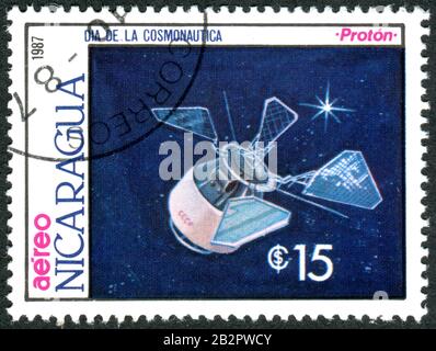 Ein in Nicaragua aufgedruckter Stempel, der dem Kosmonautiktag gewidmet ist, stellte ein Modell der sowjetischen Erdbeobachtungssatelliten dar - Proton, ca. 1987 Stockfoto