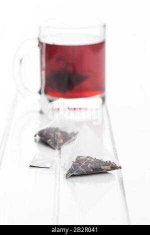 Teebeutel mit Blumenmuster auf weißem Tisch. Stockfoto