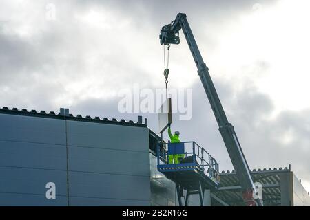 Sandwichpaneele Wandmontage mit Kran und Scherenhub Stockfoto