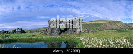 Vulkanische Felsformationen spiegelten sich in einem kleinen Teich, bei der Berghütte Skaelingar, Skafta Lave Field, in der Nähe des Flusses Skafta, Zentralhochland, Island. Stockfoto