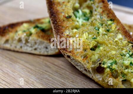 Geröstetes Knoblauchbrot auf einem Holzbrett Stockfoto