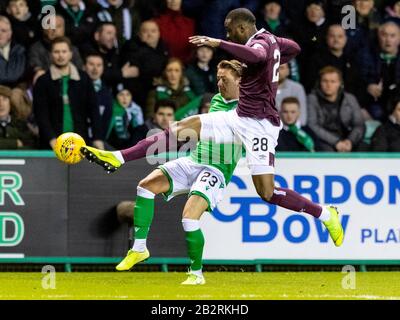 Easter Road, Edinburgh, Großbritannien. März 2020. Scottish Premiership Football, Hibernian versus Heart of Midlothian; Clevid Dikamona of Hearts räumt Scott Allan von Hibernian Credit: Action Plus Sports/Alamy Live News Stockfoto