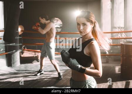 Weibliche Boxer tun Schattenboxen in einem Boxring. Boxer üben ihr bewegt sich mit Boxen Studio. Stockfoto