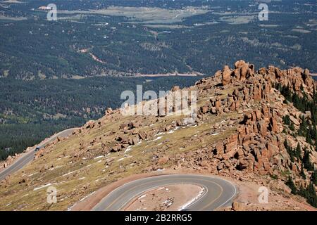 Die langsame und gefährliche Straße auf Pikes Peak in Colorado in den USA mit einem älteren Cabrio an einem sonnigen Tag einige mit Kopierraum und klarem Himmel Stockfoto