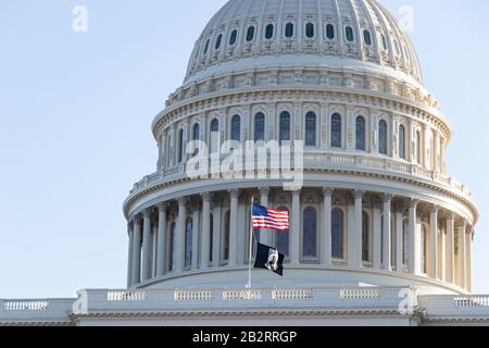 Nahaufnahme des United States Capital Dome mit der amerikanischen und der POW/MIA-Flagge, die an einem klaren Tag in Front schwenkt. Stockfoto