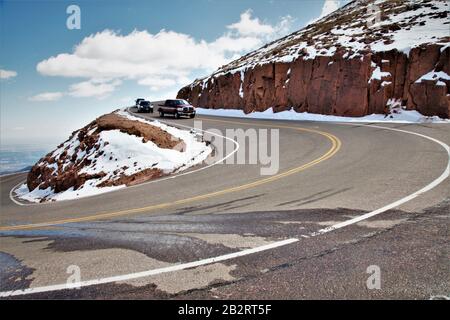 Die langsame und gefährliche Straße auf Pikes Peak in Colorado in den USA mit einem älteren Cabrio an einem sonnigen Tag einige mit Kopierraum und klarem Himmel Stockfoto