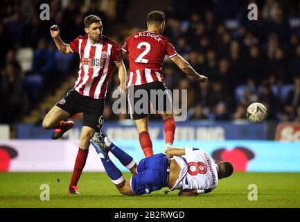 Andy Rinomhota (Boden) von Reading geht in die Box, nachdem er von Chris Basham (links) von Sheffield United und George Baldock in Angriff genommen wurde, was zu einem Elfmeter führte, während des fünften Spiels im Madejski Stadium in Reading im FA Cup. Stockfoto