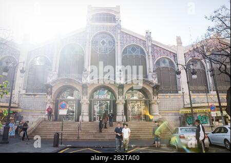 Valencia, Spanien - 17. Februar 2020: Frontansicht auf dem Mercado Central und Besucher mit Hintergrundbeleuchtung Stockfoto