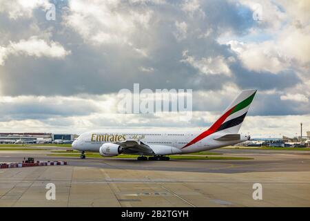 Emirates Airbus A380-861 steht auf der Startbahn des Flughafens London-Heathrow auf der Startbahn und wartet unter dunklen Wolken auf den Start Stockfoto