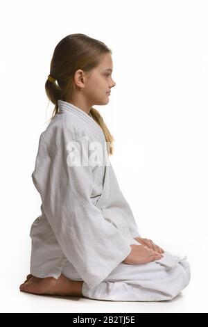 Judo-Student sitzt auf dem Boden, von der Seite aus betrachtet Stockfoto