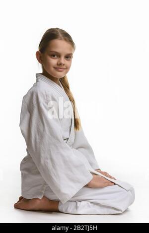 Mädchen in der Judo-Klasse, auf dem Boden sitzend, der Blick von der Seite Stockfoto