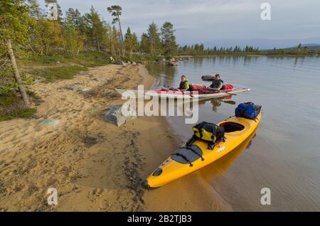 Paar im Paddelboot eine Einems, das dem Strand am See Rogen Naturreservat, Rogen, Haerjedalen, Schweden, August 2011 Stockfoto