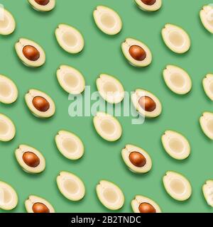 Muster mit Avocado-Schichten auf grünem Hintergrund. Stockfoto