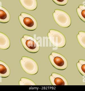 Muster mit Avocado-Schichten auf grünem Hintergrund. Stockfoto