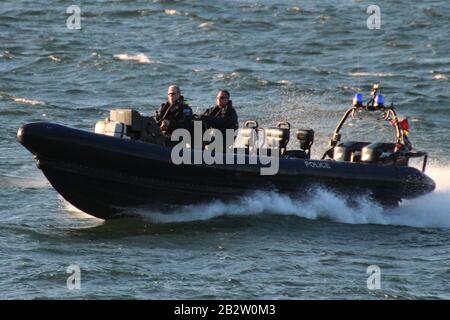 Ein Verteidigungsministerium, RHIB, vor Gourock am Firth of Clyde, fungiert als Eskorte zu einem ankommenden U-Boot der Royal Navy Trafalgar-Klasse. Stockfoto